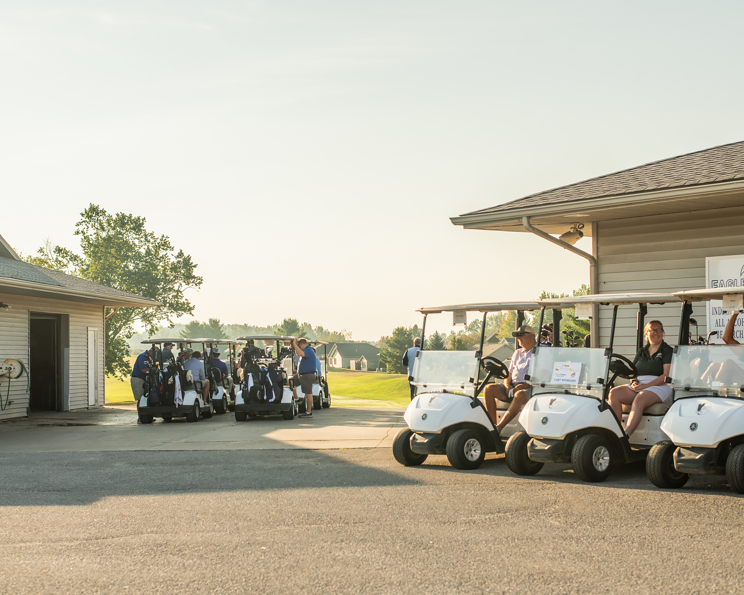 A photo of golf carts parked in a uniform line along a building at a golf course for the annual Mission 25 Driving Hope Golf Outing